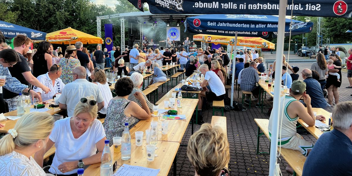 Gäste beim Sommerfest des Lions Club Maintal mit Bühne und Biertischen